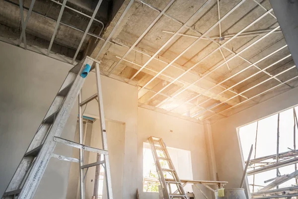 Install metal frame for plaster board ceiling at house under construction