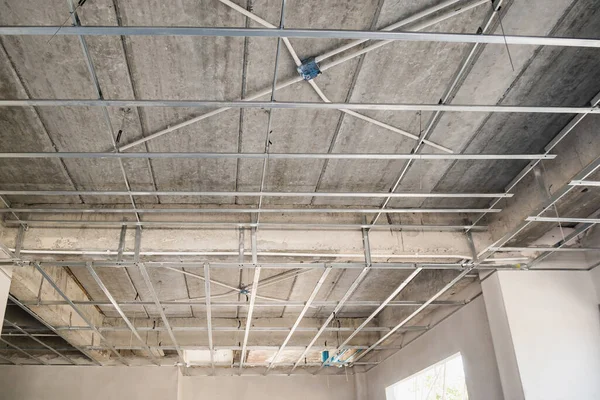 Install metal frame for plaster board ceiling at house under construction