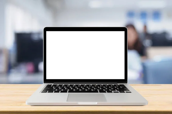 Ofis içi bulanık masadaki boş ekranlı dizüstü bilgisayar.