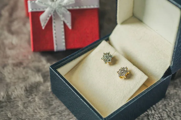 Jewelry gold diamond earring with gift box background