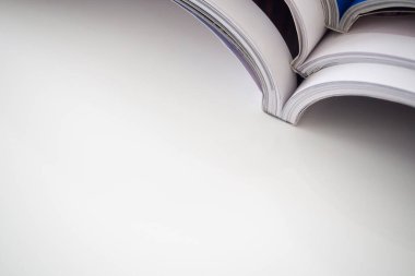 Oturma odasındaki beyaz masaya yığılmış dergiler yığını, kapatın.