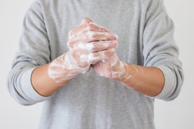 Erkek, COVID-19 Corona virüs önleme konsepti için sabunla ellerini yıkıyor.