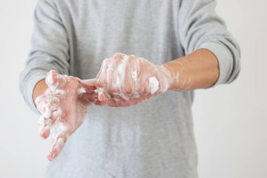 Erkek, COVID-19 Corona virüs önleme konsepti için sabunla ellerini yıkıyor.