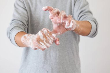 Erkek, COVID-19 Corona virüs önleme konsepti için sabunla ellerini yıkıyor.