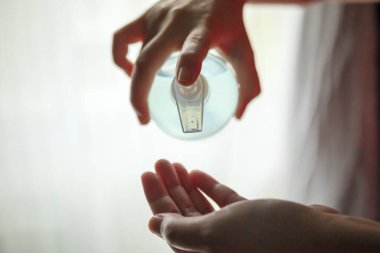 Kadın, COVID-19 Corona virüs önleme konseptini temizlemek için alkol dezenfektanı kullanıyor.