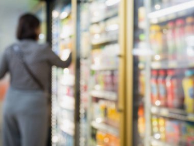 Süpermarketteki ya da marketteki soğuk dondurucunun raflarında duran soğuk içecek şişeleri.