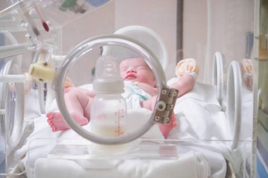 Yeni doğmuş bebek doğum odasındaki kuvözün içinde.