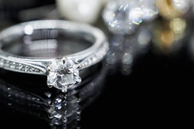 Siyah arka planda yansıması olan lüks mücevher yüzükleri.