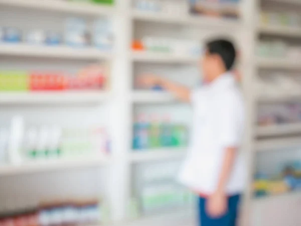 Imagen Borrosa Del Farmacéutico Tomando Medicamentos Estantería Farmacia —  Fotos de Stock