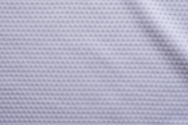 Beyaz kumaşlı spor giyimli futbol forması, hava ağı desenli.