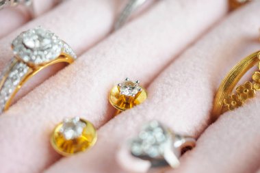 Altın ve gümüş elmas yüzük ve küpeler lüks mücevher kutusunda.