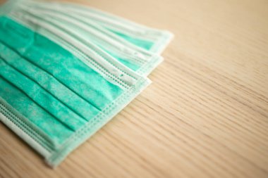 Covid-19 Coronavirus önleme konsepti için ahşap masadaki tıbbi yüz maskesi