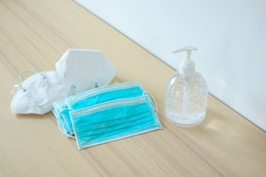 Covid-19 Coronavirus önleme konsepti için ahşap masaya alkol dezenfektanlı yüz maskesi.