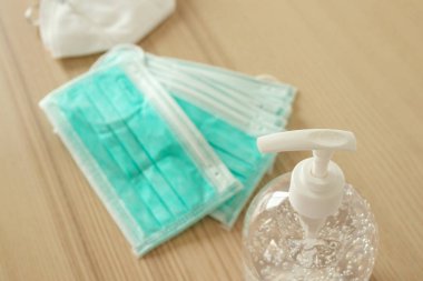 Covid-19 Coronavirus önleme konsepti için ahşap masaya alkol dezenfektanlı yüz maskesi.