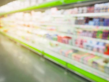 Süpermarket buzdolabı rafları ve arka planda bulanık içki şişeleri.