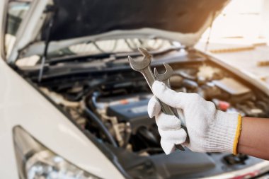 Tamir garajında araba motoru olan otomatik tamirci el anahtarı.