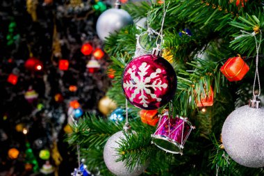 Işıl ışıl ışıl arka planda renkli mücevherlerle süslenmiş Noel ağacı.