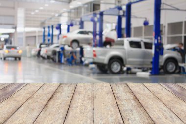 Ürünlerinizi görüntülemek ya da montajlamak için, bulanık garaj arka planlı ahşap masa üstü