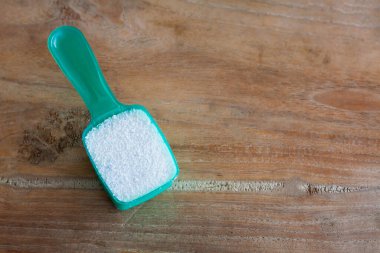 Deterjan tozu, deterjan deterjan, tahta arka plandaki kaşık.