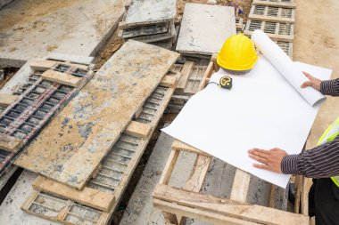 Genç iş adamı profesyonel mühendis bina inşaatında proje üzerinde çalışıyor.