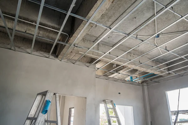 Install metal frame for plaster board ceiling at house under construction