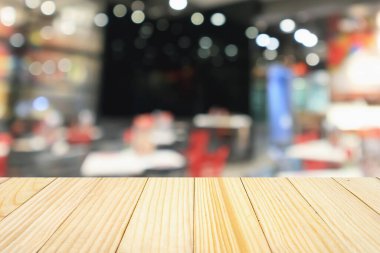 Lokanta kafeli ahşap masa ya da kafenin içi soyut odaklı bulanık arka planı olan insanlarla dolu.