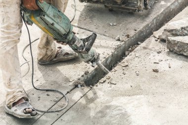 İnşaat işçisi beton sondaj yüzeyi kullanıyor.