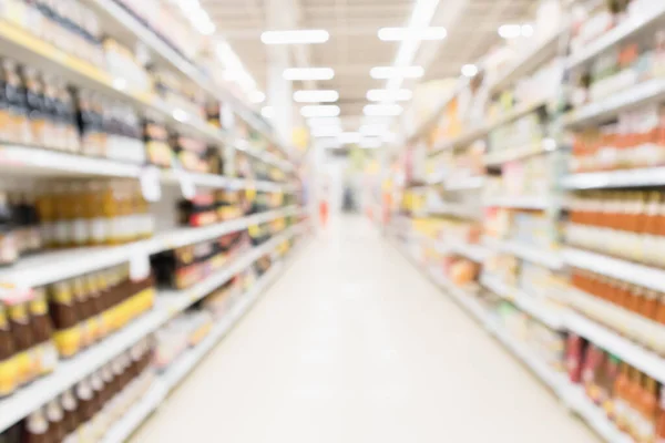 Abstract blur supermarket discount store aisle and seasoning sauce product bottle shelves interior defocused background