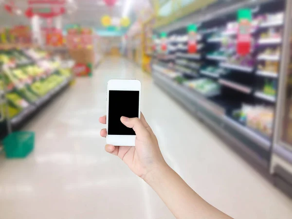 Mão Segurando Telefone Celular Com Legumes Frutas Prateleira Supermercado Desfocado — Fotografia de Stock