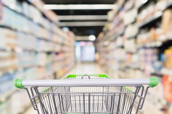 Soyut bulanık süpermarket koridoru boş yeşil alışveriş arabasıyla odaklanmış arka plan
