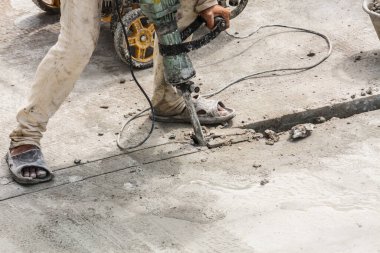 İnşaat işçisi beton sondaj yüzeyi kullanıyor.