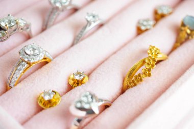 Altın ve gümüş elmas yüzük ve küpeler lüks mücevher kutusunda.