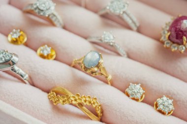 Altın ve gümüş elmas elmas yüzük ve küpeler lüks mücevher kutusunda.