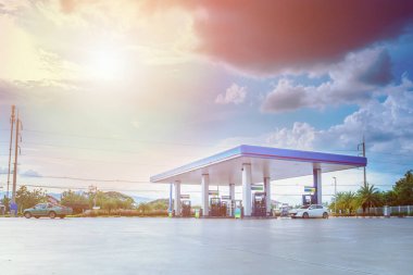 Bulutları ve mavi gökyüzü olan benzin istasyonu