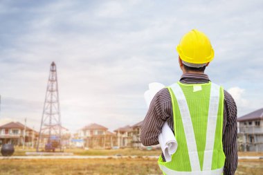 Asyalı işadamı inşaat mühendisi. İnşaat alanında koruyucu miğferi var.