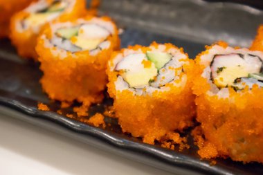Kaliforniya maki suşisi siyah tabakta, Japon yemeği.