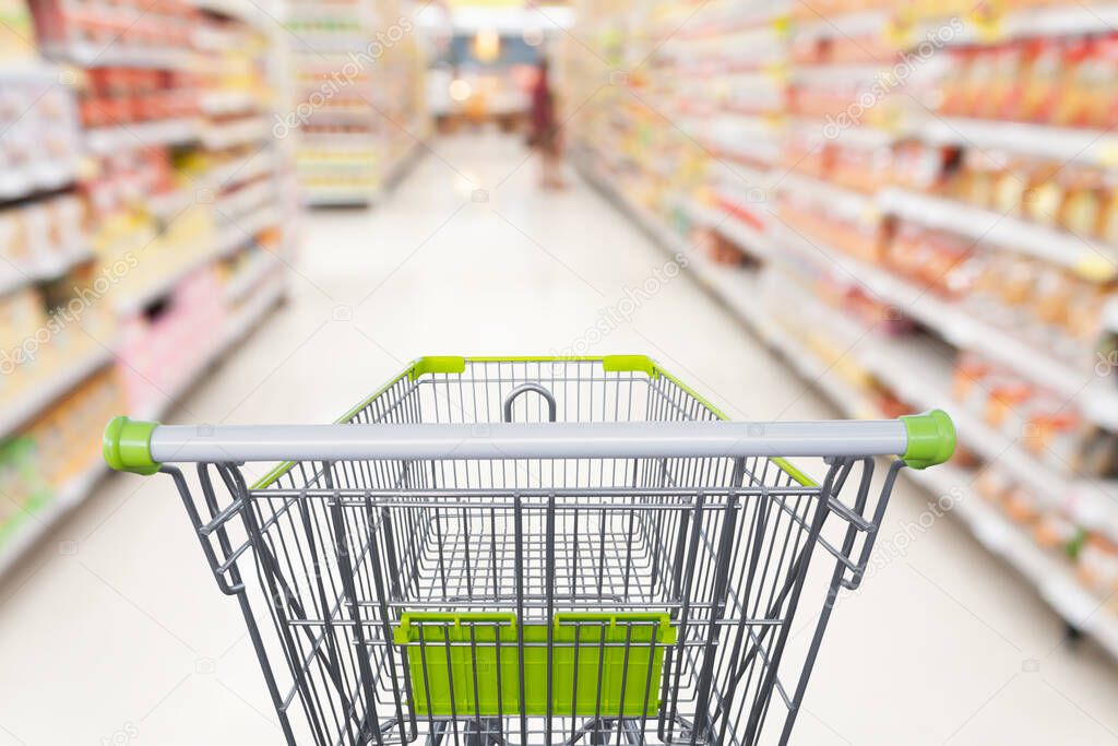 Supermarket aisle with empty shopping cart at grocery store retail business concept