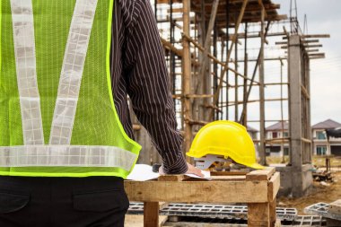 Genç iş adamı profesyonel mühendis bina inşaatında proje üzerinde çalışıyor.