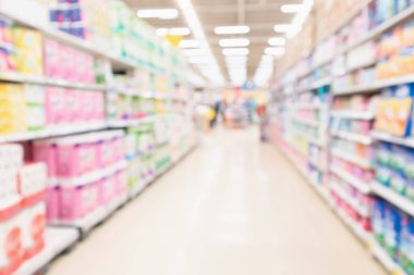 Bulanık süpermarket koridoru ve çeşitli tuvalet kağıdı görüntüleriyle dolu raflar