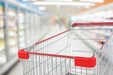 Süpermarket koridoru boş kırmızı alışveriş arabasıyla bulanık arka plan