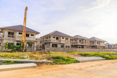 Bulutları ve mavi gökyüzü olan konut inşaatındaki yeni ev.