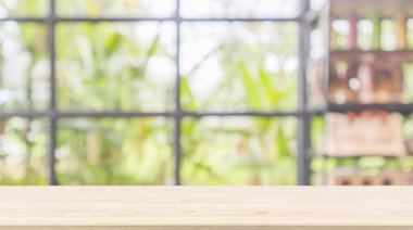 Boş ahşap masa üstü soyut bulanık kahve dükkanı ya da kafeterya arka planında montaj ürünü görüntüleme için bokeh ışığı olan