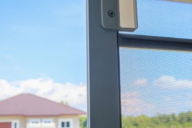 Ev penceresinin böceklere karşı korunması için sivrisinek ağı ekranını aç