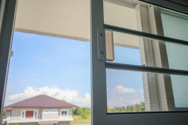 Ev penceresinin böceklere karşı korunması için sivrisinek ağı ekranını aç