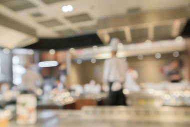 Aşçı, restoran mutfağında yemek pişiriyor. Soyut, bulanık arka plan.