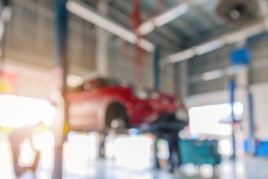 Otomotiv servis merkezindeki bakım istasyonunda kırmızı araba kaldırışı soyut arkaplan bulanıklığı