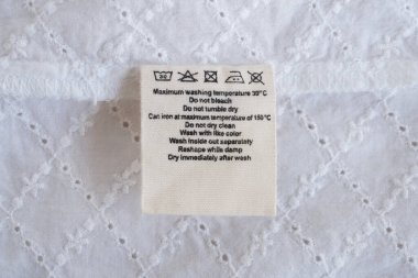 Çamaşır yıkama talimatları kumaş dokusu arka planında etiket