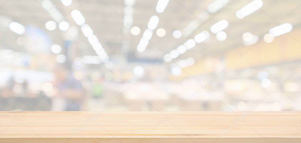 Empty wood table top with supermarket grocery store blurred defocused background with bokeh light for product display