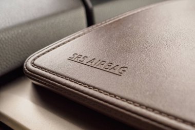 Modern arabanın kahverengi deri dokusunda hava yastığı güvenlik işareti var.