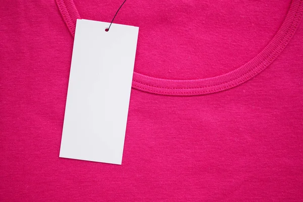 stock image Blank white clothes tag label on new pink shirt